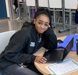 girl sitting at table with computer