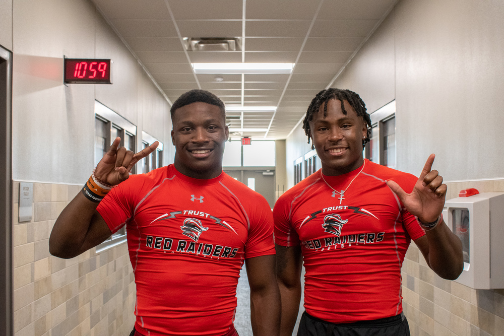 Jamarion Miller holding up hook 'em hand sign and Bryson Donnell holding up wreck 'em hand sign