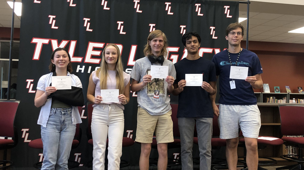 five high school boys and girls holding certificates in front of them