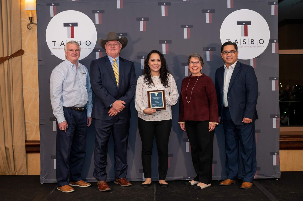 men and women standing in front of TASBO logo on wall, holding award