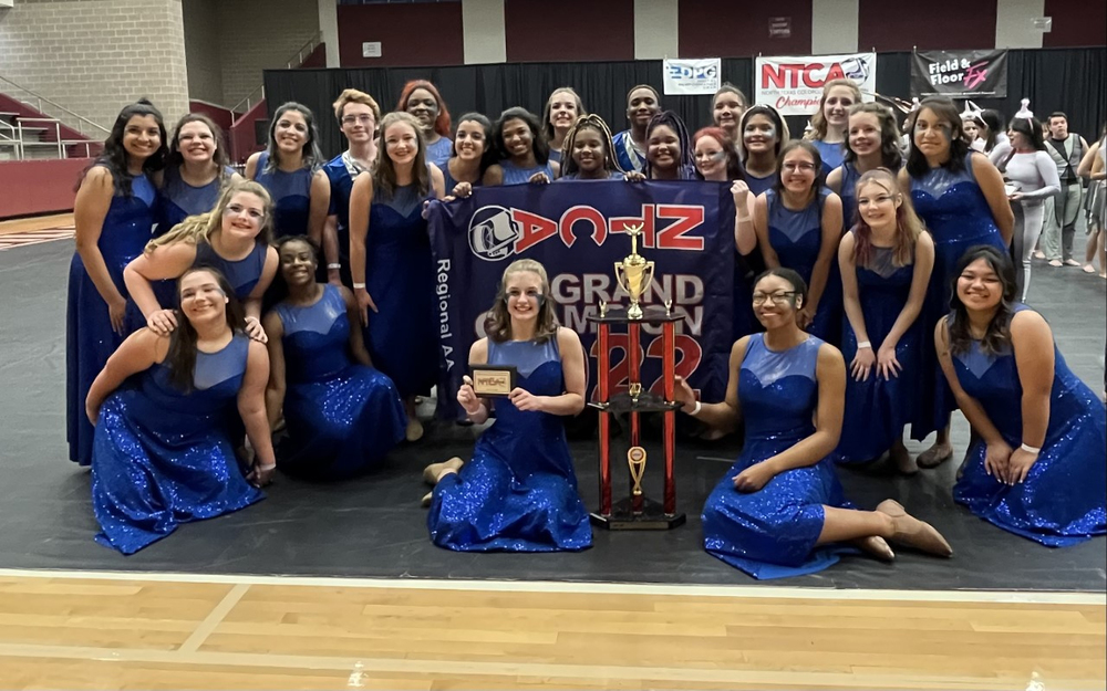 Tyler Legacy color guard girls pose with their grand champion trophy