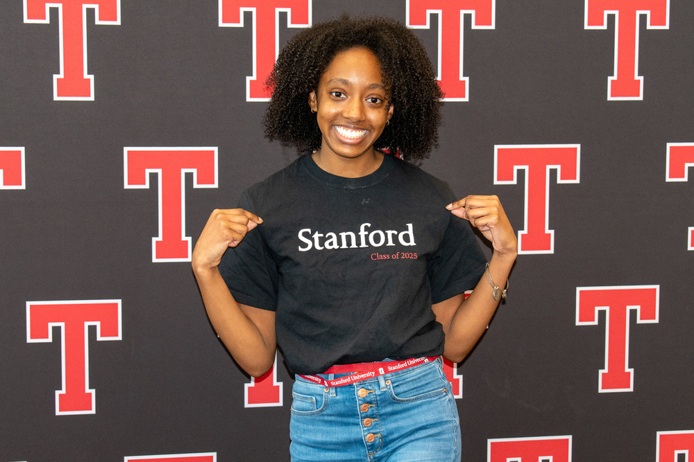 High school African American girl proudly showing off her Stanford t-shirt