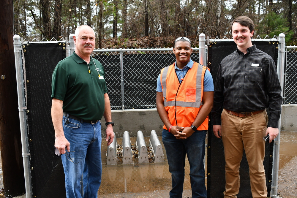 Joe Williams, Christopher Whitmore and Hayden McMullen stand in front of filters created for storm drains