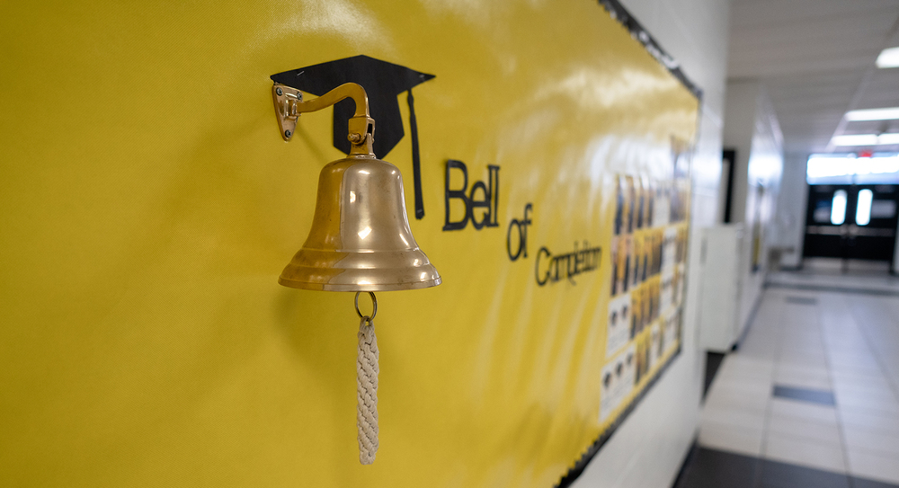 bell hanging on wall with yellow background