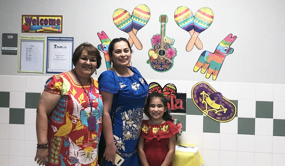 two women and a young girl wearing traditional Mexican dresses
