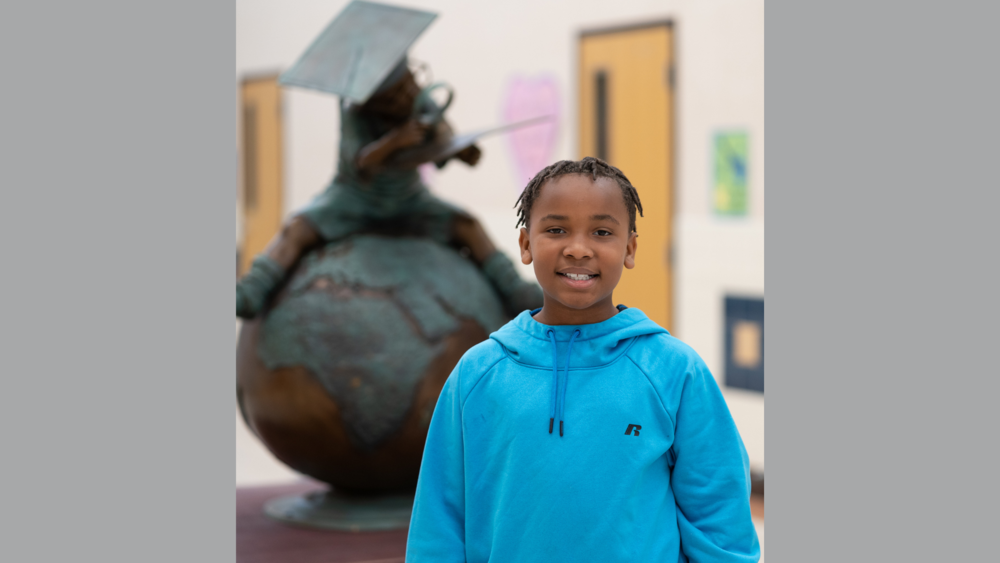 African American elementary age boy wearing a blue hoodie