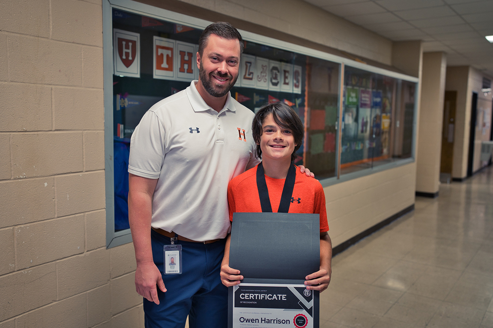 Hubbard Middle School principal Geoffrey Sherman and 7th grade student Owen Harrison, holding his student of the month certificate