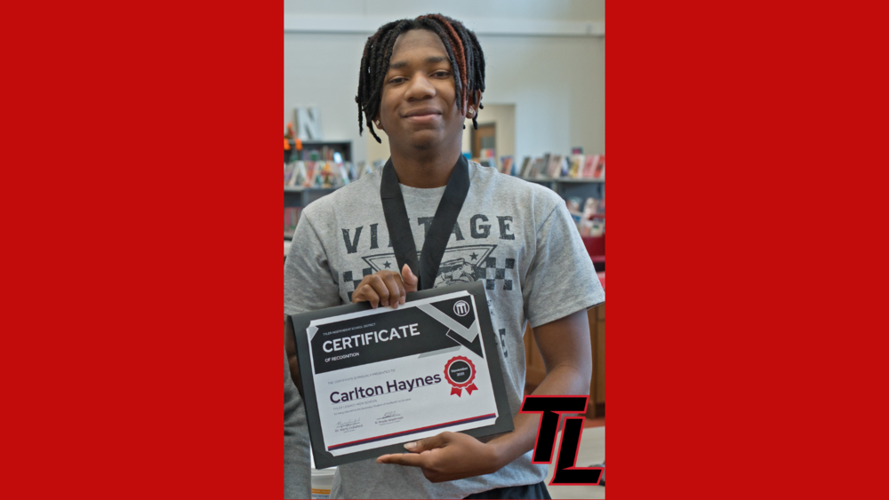 Legacy student Carlton Haynes, Jr. holds his certificate for being named  student of the month