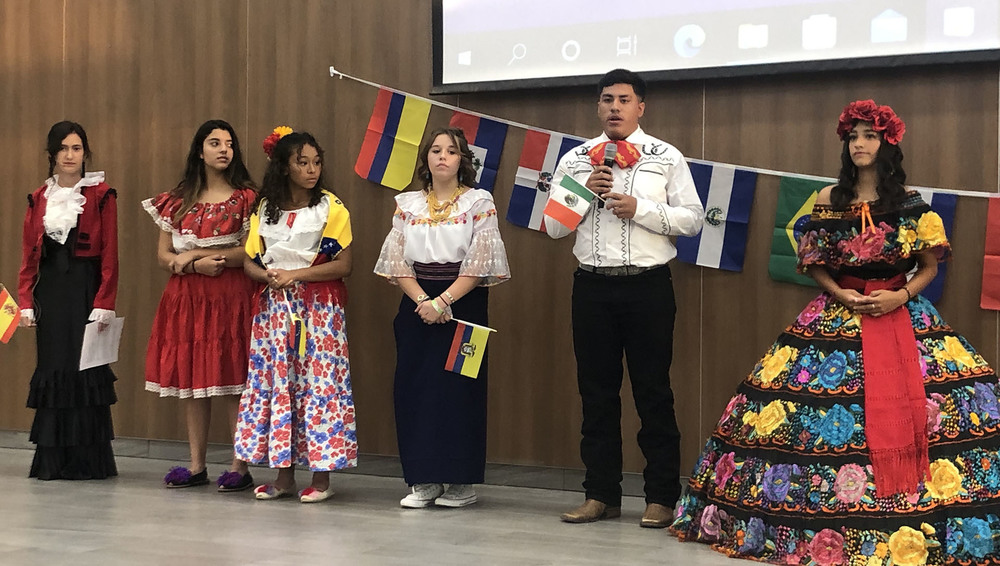 high school students dressed in traditional Hispanic shirts, dresses, skirts