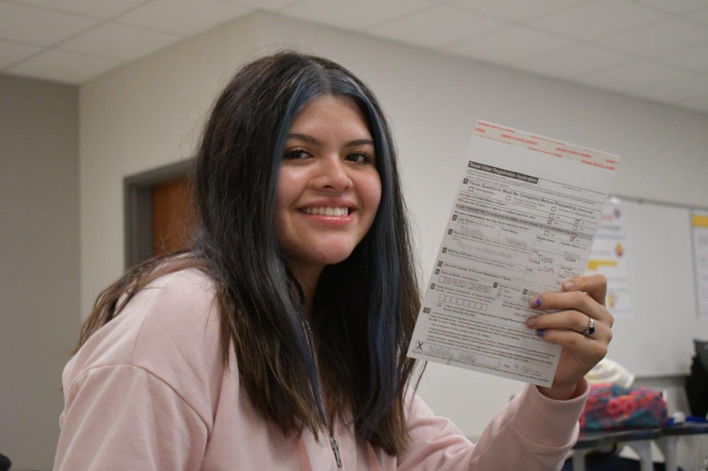 student holding her voter registration form