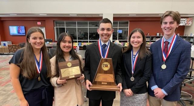 high school students wearing red, white and blue ribbons with medals around their necks. two of them are holding plaques they earned for winning UIL contest