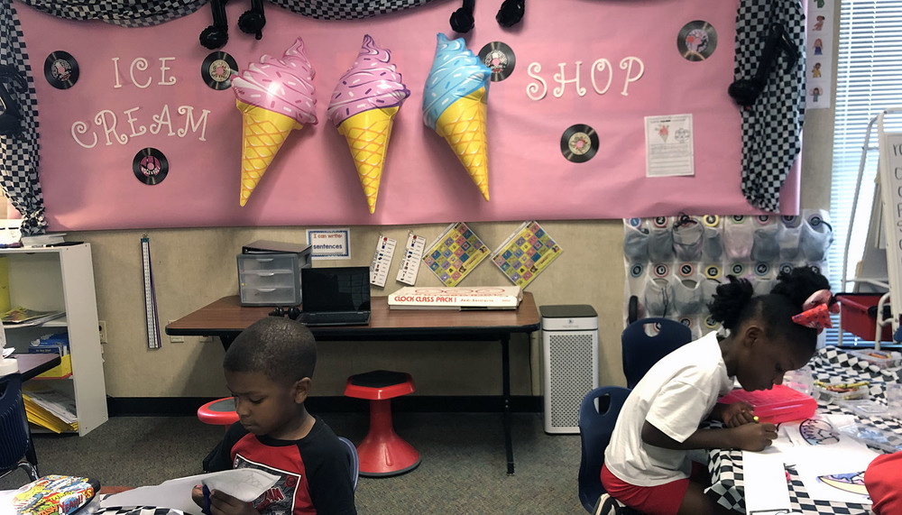 elementary classroom with pink bulletin board that says, "Ice cream shop" with giant ice cream cones
