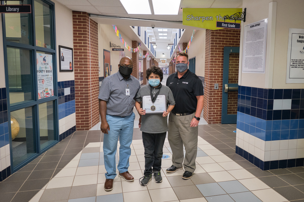 Jacob Gutierrez, a 5th-grade student at T. J. Austin Elementary School is the Elementary Student of the Month posing with the principal and superintendent.