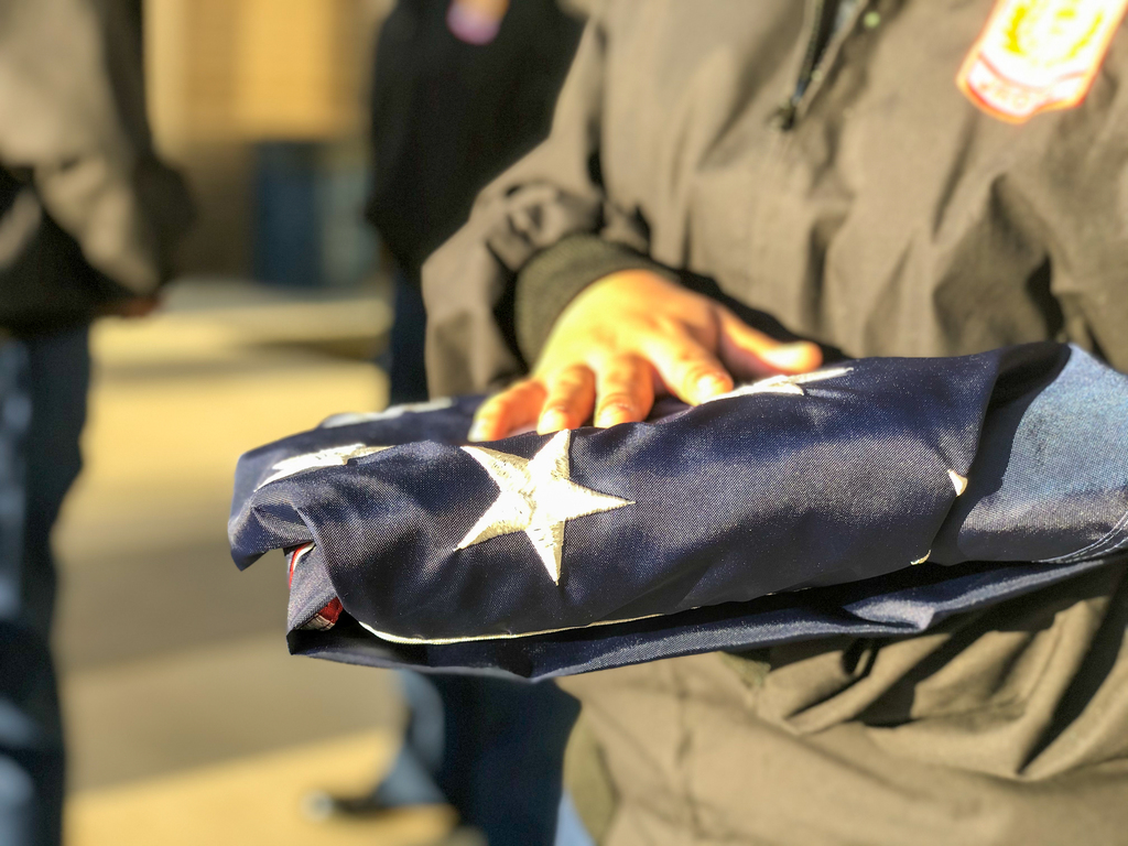 Tyler High student holding a folded flag prior to flag raising.