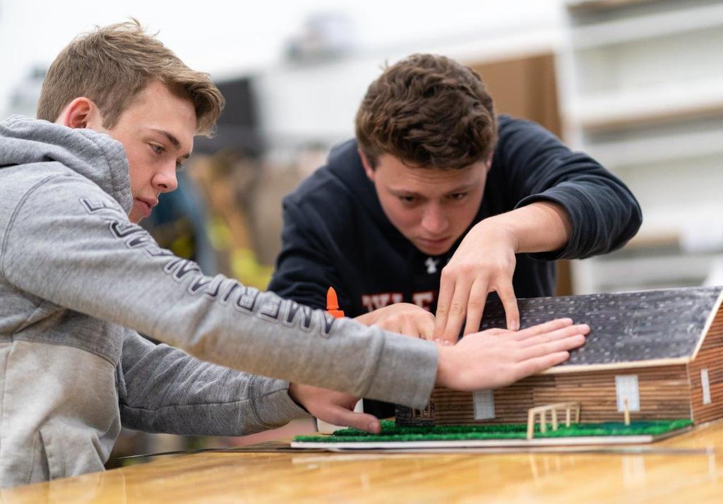 two high school students working on a model home