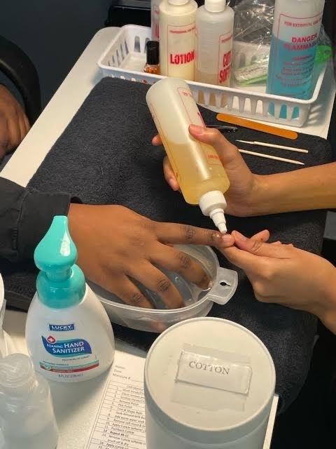 2 sets of hands with one putting cuticle oil on the other.