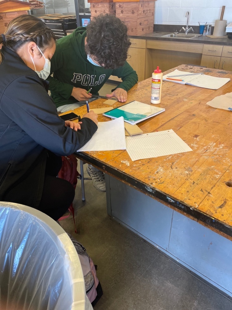 2 students draw up plans for their tiny home design.