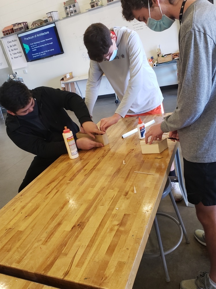 3 students work together to create their design.