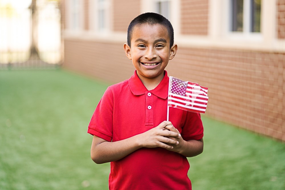student holding a US flag