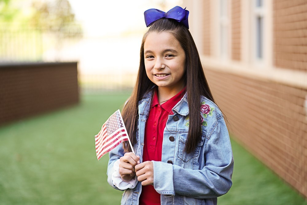 student holding a US flag