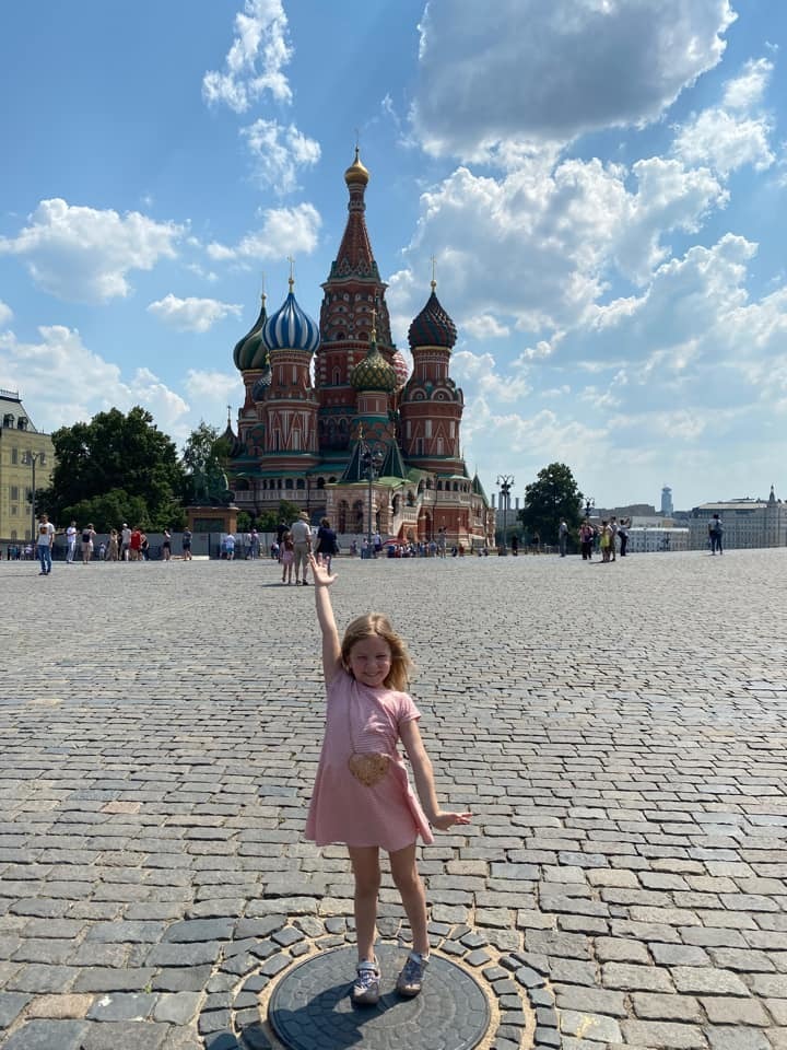 Little girl poses in front of St. Basil's Cathedral in Moscow, Russia