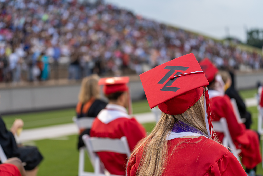 Graduate sitting at commencement ceremony with view of graduation cap