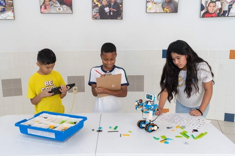 three students working together to make a robot work