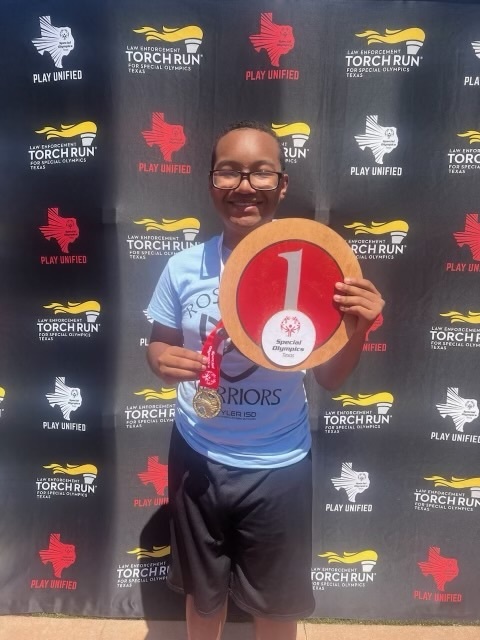 student in front of special Olympics sign