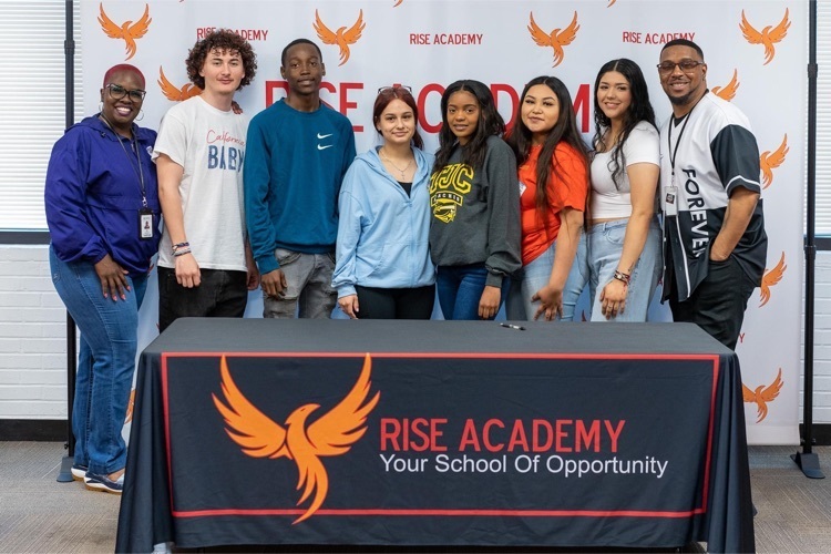 rise academy seniors posing in front of backdrop
