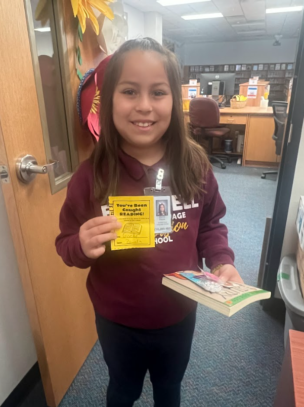 3rd grade student winning a prize for being caught reading