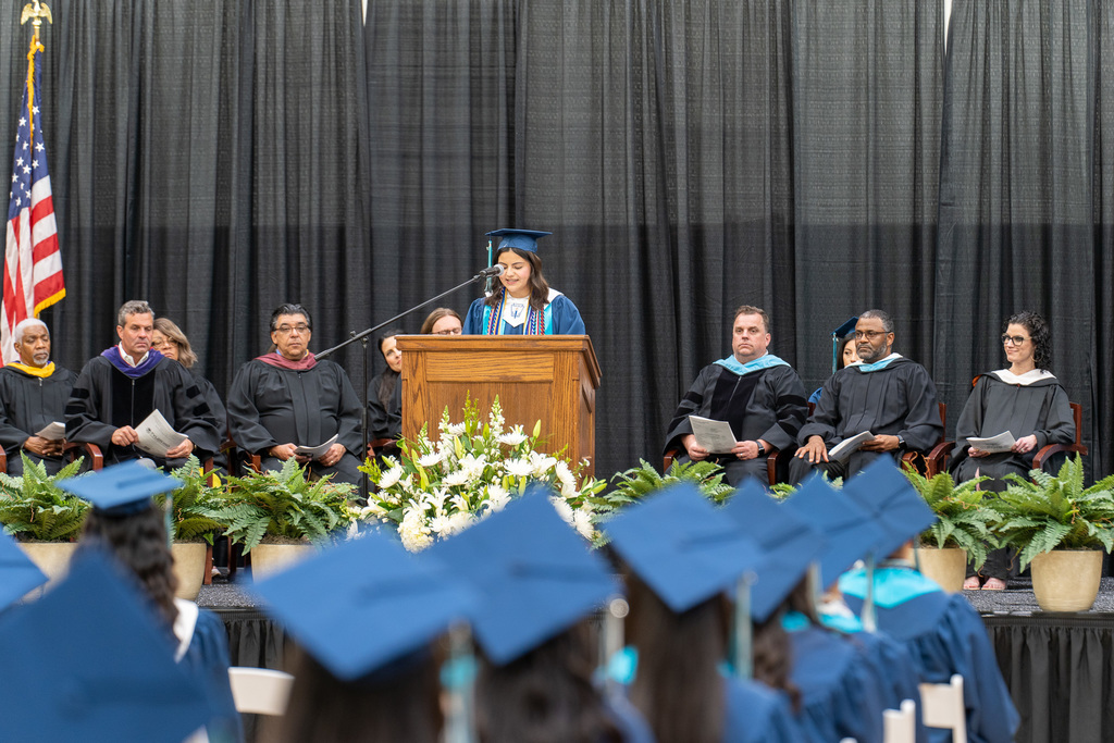 early college high school graduation with the focus on the speaker at the podium