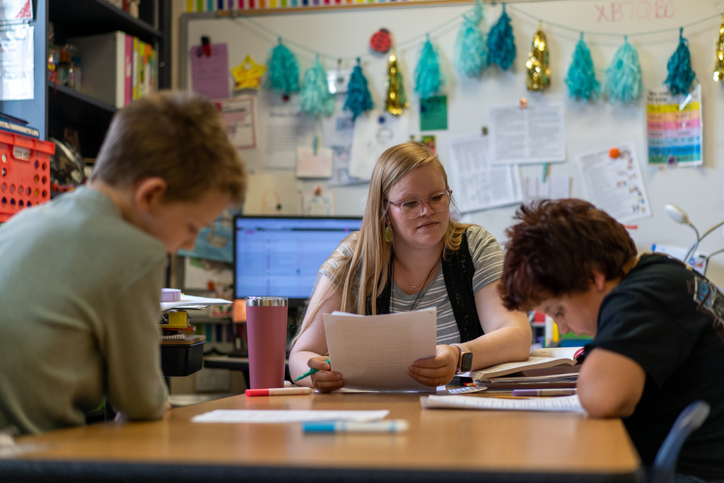 teacher with student working on paper