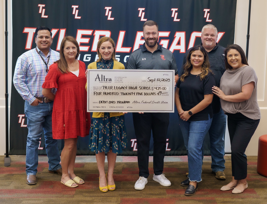 Altra holding a check at Tyler Legacy High School