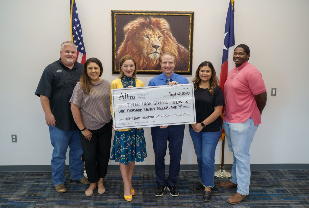 Altra holding a check at Tyler High School